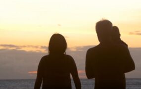 夕阳下海边一家三口背影视频素材