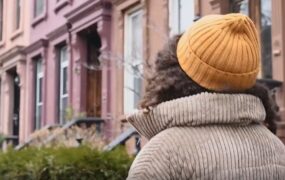 美女冬季行走房屋边背影视频素材