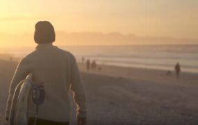 夕阳下手拿冲浪板男生上半身背影视频素材