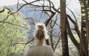 美女清晨林间晒太阳背影视频素材