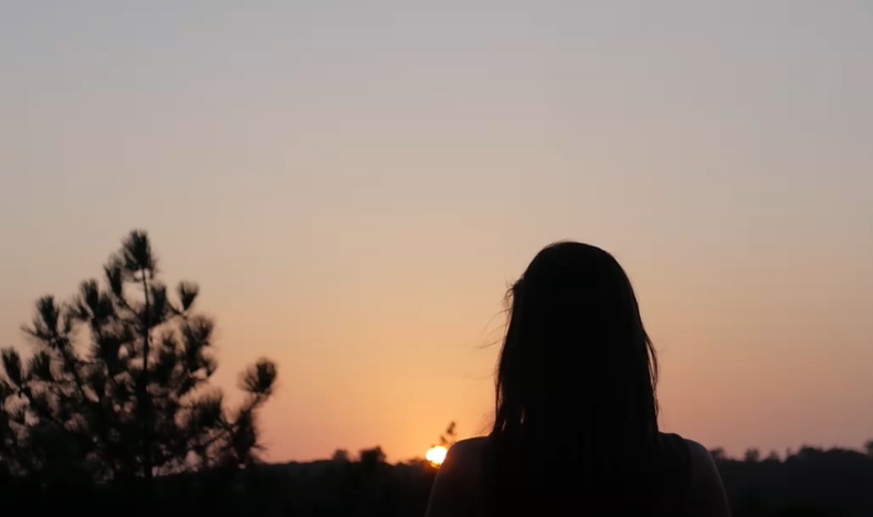 女子面对夕阳做瑜伽短视频素材