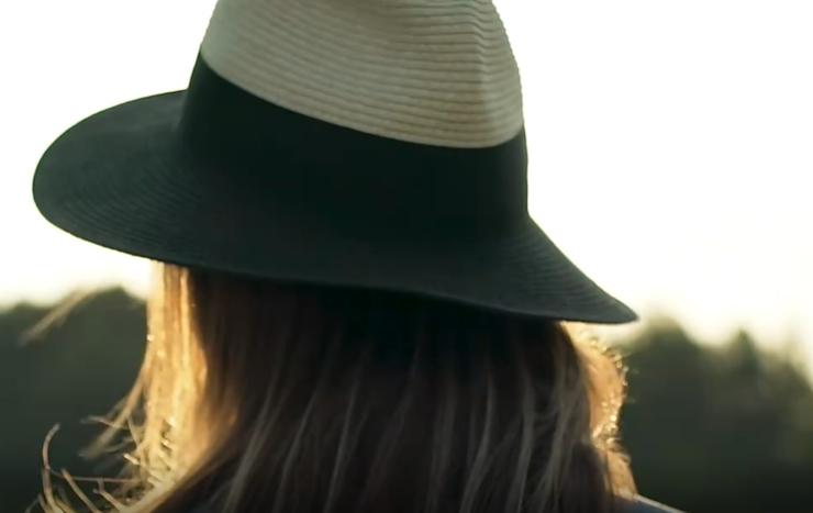 阳光下戴帽女子背影镜头短视频素材