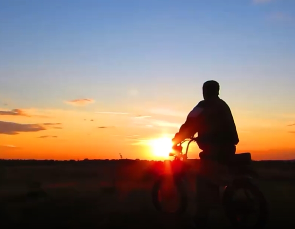 朝霞中男子骑着自行车镜头短视频素材