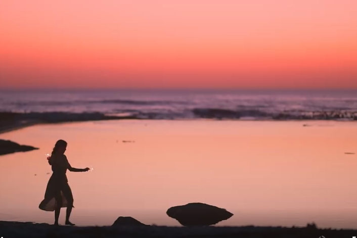 女子在晚霞中的海边玩烟花短视频素材