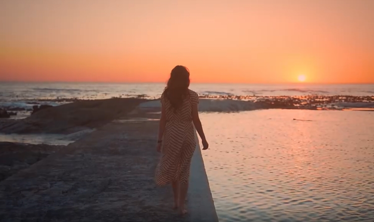 女子赤脚行走在海边镜头短视频素材