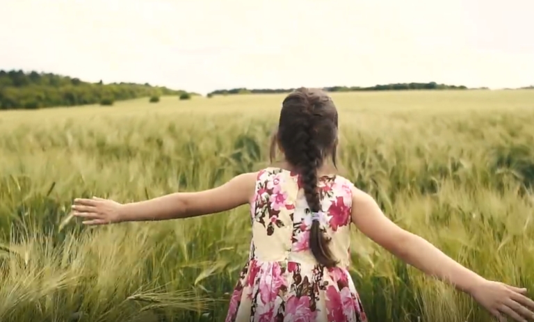 小女孩穿着碎花裙跑在绿油油麦田里人物视频素材