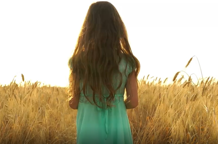 身穿绿色连衣裙小女孩快速奔跑在麦田里治愈视频素材