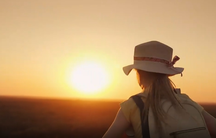 小女孩背着包奔向太阳的镜头视频素材