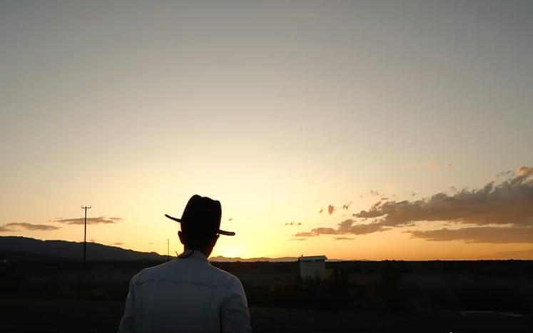 戴帽子男子晨光里在沙漠行走人物视频素材