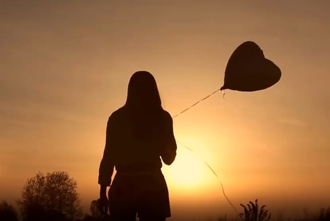 清晨迎着阳光拿着气球走路的女子人物视频素材