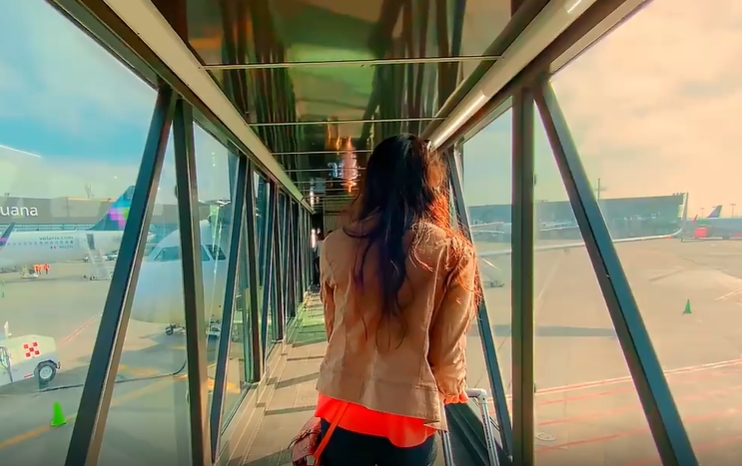 穿皮夹克美女拖着行李箱在飞机场行走人物视频素材