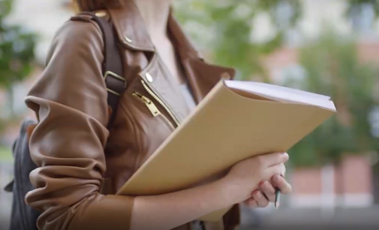 拿着书本短发美女校园街头慢走人物视频素材