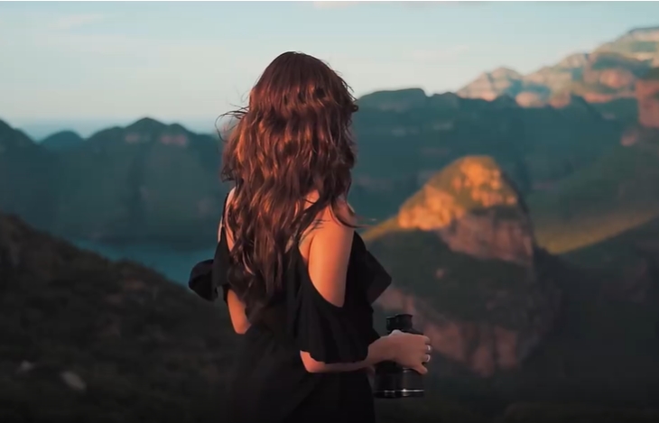 夕阳下美女拿着望远镜瞭望山川人物视频素材