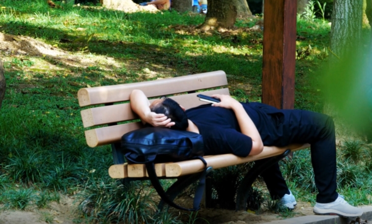 在公园长凳躺着午休的失业人员短视频素材