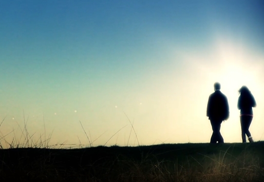 夕阳下行走的情侣特写镜头