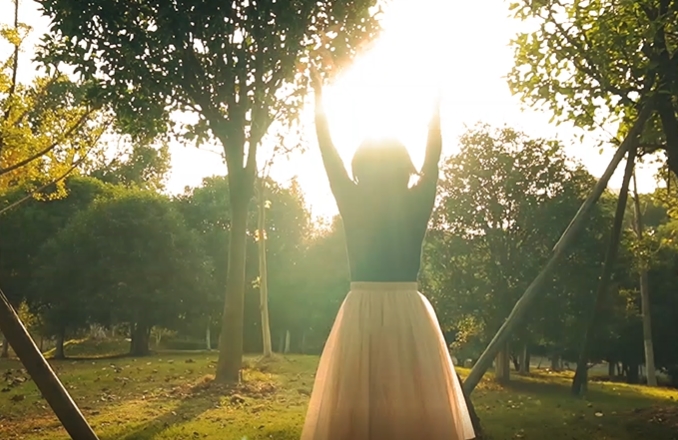 森林你女孩迎着阳光抛洒树叶