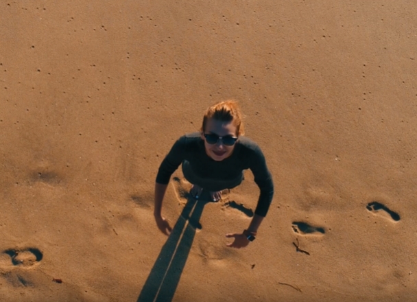 在海边沙滩上张开双手仰望天空