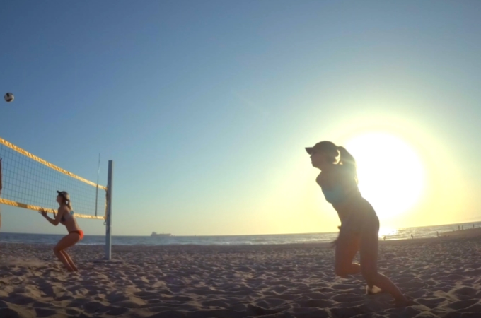 日光下的沙滩排球女孩子们视频素材