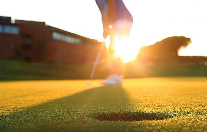 清晨草地上高尔夫球进洞