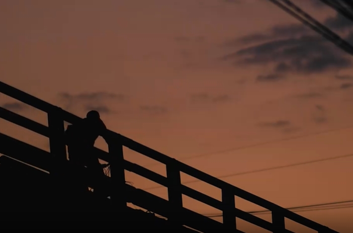 行人傍晚大桥骑车侧影视频素材