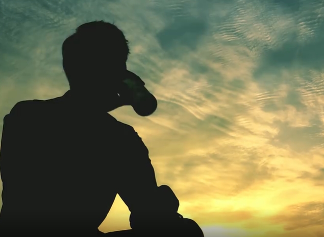 男子在天空下孤独的喝酒视频素材