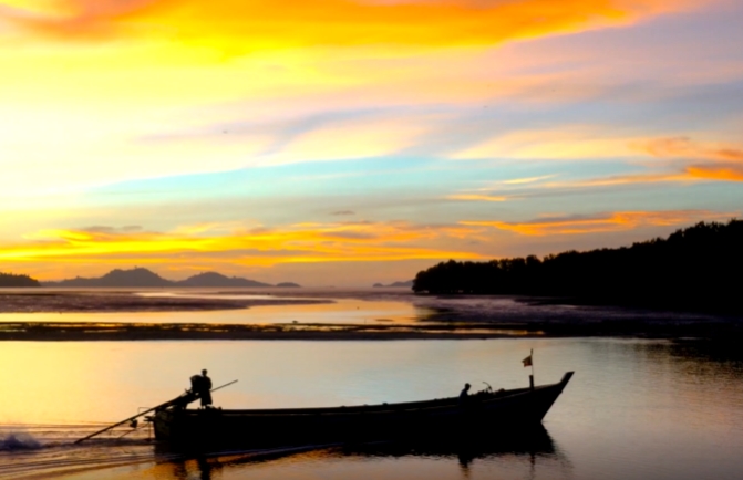 夕阳下一艘孤舟缓缓驶过水面视频素材