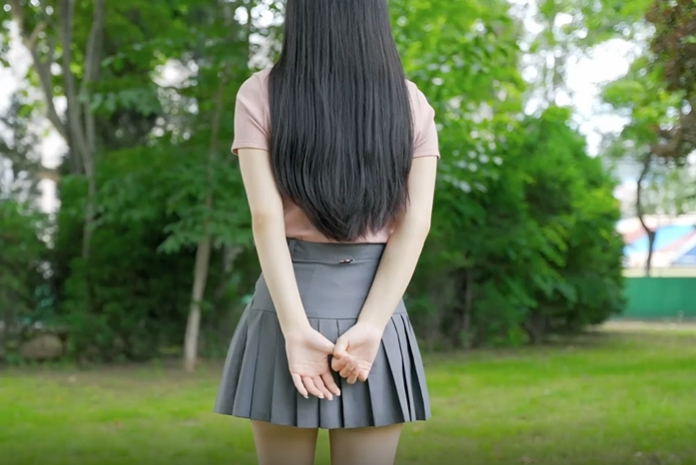 清纯的女孩子草地上行走的背影