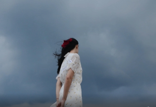 乌云下的女孩迎风吹舞