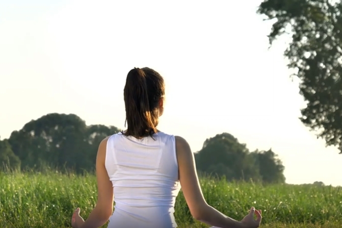 清晨在草地打坐的女人视频素材